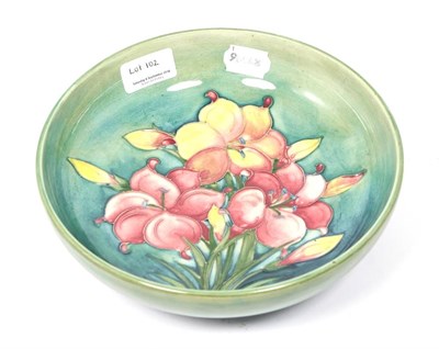 Lot 102 - A Walter Moorcroft African Lily Pattern Bowl, on a green ground, impressed factory marks and...