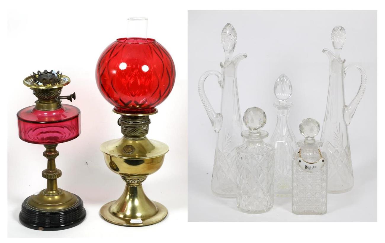 Lot 37 - Two oil lamps and five glass decanters with stoppers