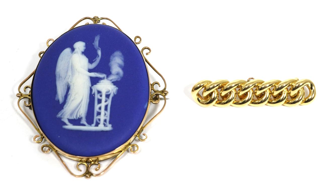 Lot 76 - A Wedgwood blue Jasperware brooch, the oval plaque depicting Nike, in a scroll frame, measures...