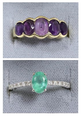 Lot 96 - An emerald and diamond ring, an oval cut emerald in a claw setting, to diamond set shoulders, total