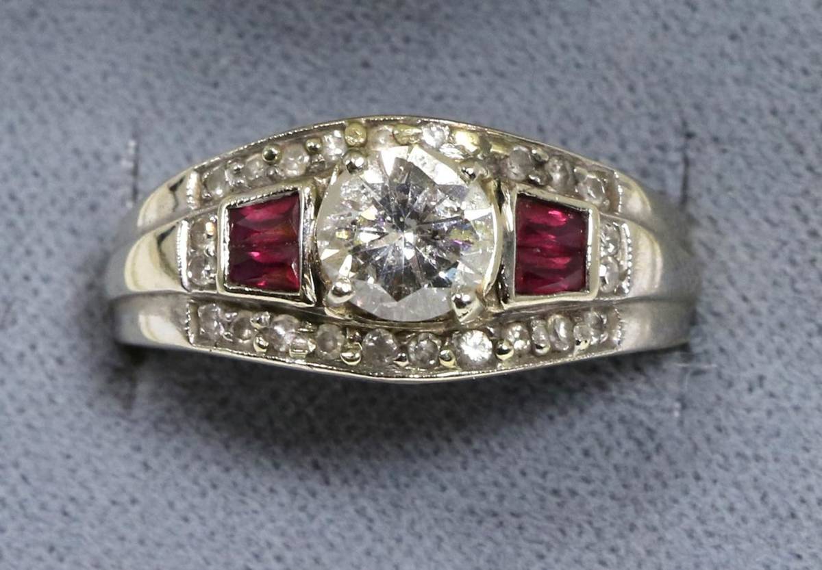 Lot 101 - An Art Deco style ruby and diamond ring, a round brilliant cut diamond in a claw setting, spaced by