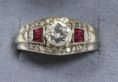 Lot 101 - An Art Deco style ruby and diamond ring, a round brilliant cut diamond in a claw setting, spaced by
