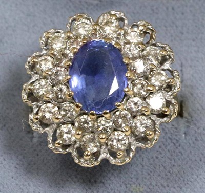 Lot 103 - A 9 carat gold sapphire and diamond cluster ring, an oval cut sapphire in a claw setting within...