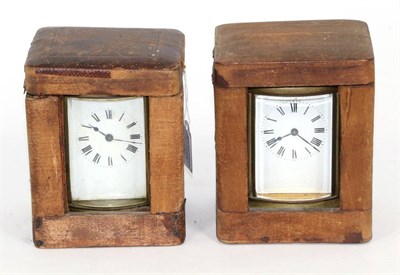 Lot 115 - Two brass oval carriage timepieces, both with fitted travelling cases