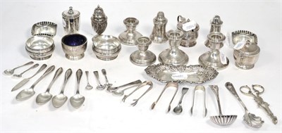 Lot 240 - A collection of assorted silver salts, pepperettes, mustard, squat candlesticks, sugar tongs...