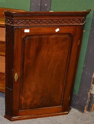 Lot 1046 - An early 19th century mahogany corner cupboard