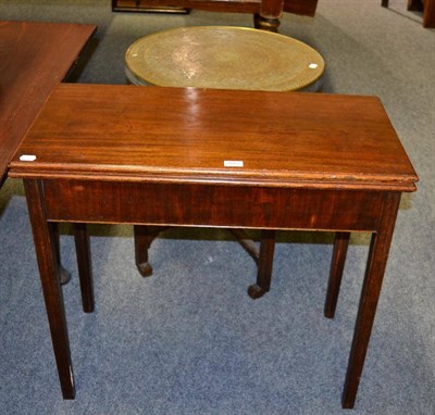 Lot 1052 - A mahogany fold over tea table and an Indian style copper topped table with folding wooden base