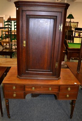 Lot 1053 - An early 19th century oak corner cupboard and a mahogany side table with central drawer and...