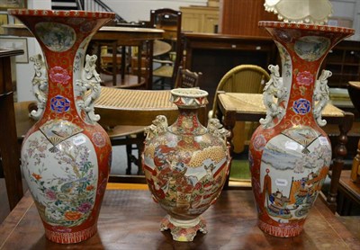 Lot 1069 - A pair of Japanese baluster vases, Meiji period, each with twin dragon handles, everted rims,...