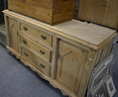 Lot 1097 - A reproduction pine sideboard with three central drawers and two side doors