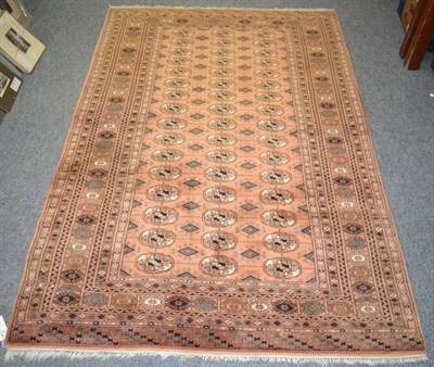 Lot 1183 - Lahore 'Bukhara' rug, Pakistan, the faded peach field with columns of quartered guls enclosed...