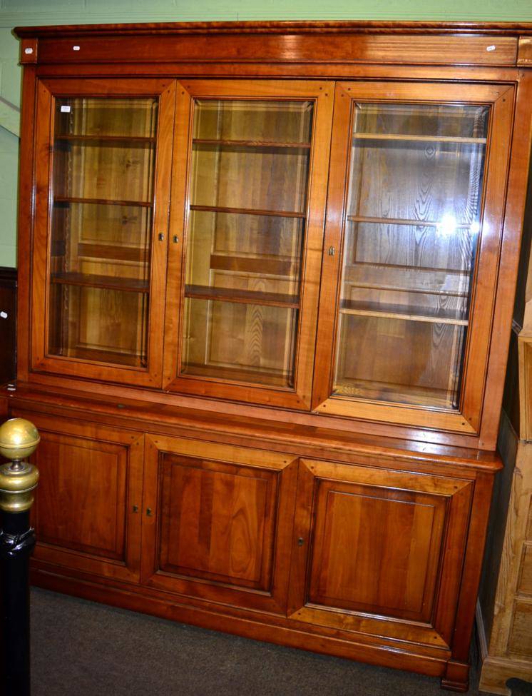 Lot 1201 - A light mahogany glazed bookcase the base with three doors