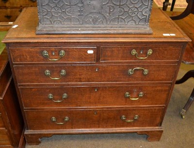 Lot 1290 - An early 19th century oak and mahogany cross banded chest of drawers comprising three long...