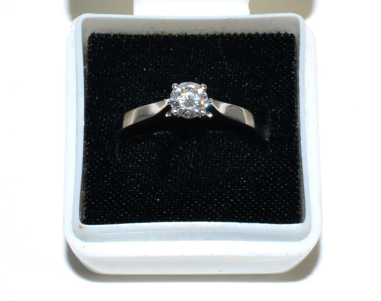 Lot 60 - A platinum solitaire diamond ring, a round brilliant cut diamond in a claw setting, to knife...