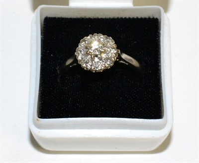Lot 87 - A diamond cluster ring, a round brilliant cut diamond within a border of illusion set eight-cut...