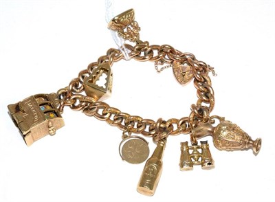 Lot 88 - A chased curb link charm bracelet, stamped '9CT', with a padlock clasp and seven charms,...