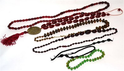 Lot 91 - Three red plastic bead necklaces, a faceted green glass necklace, a bovine horn bead necklace and a