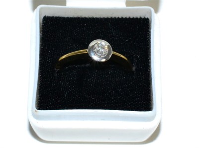 Lot 96 - An 18 carat gold solitaire diamond ring, a round brilliant cut diamond in a broad rubbed over...