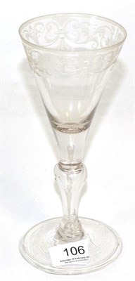 Lot 106 - A light baluster wine glass, circa 1750, the funnel bowl engraved with a band of scrolling foliage