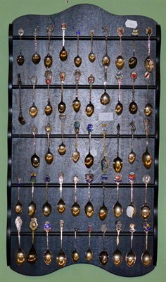 Lot 148 - A rack containing a group of collectors spoons with approximately twenty one silver examples