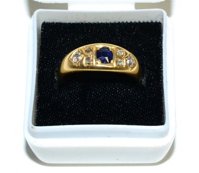 Lot 203 - An 18 carat gold sapphire and diamond ring, a round cut sapphire spaced by groups of old cut...