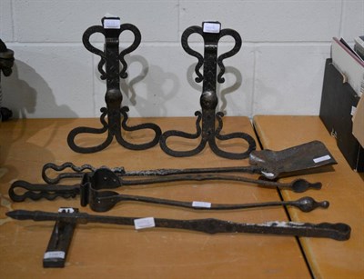 Lot 1097 - A cast iron Arts & Crafts fire side set comprising, andirons, tongs, poker, shovel and poker stand