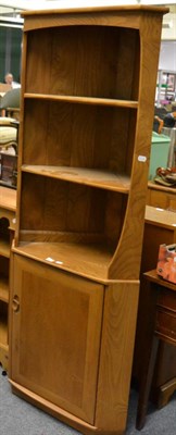 Lot 1144 - An Ercol light elm corner cupboard