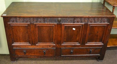 Lot 1183 - An 18th century oak four panelled coffer, fitted with two base drawers, containing a quantity...