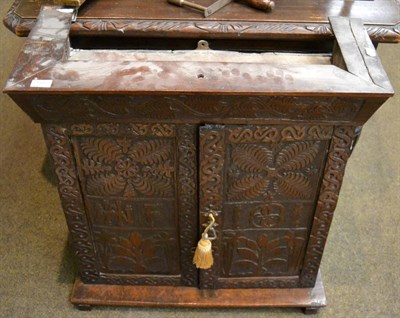 Lot 1192 - Carved oak double door cabinet enclosing one shelf