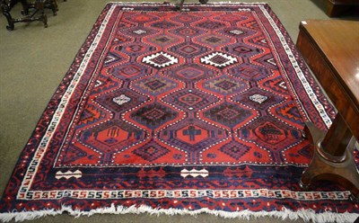 Lot 1223 - Kurdish rug, Persian Kurdistan, the tomato red stepped lattice field of serrated guls enclosed...