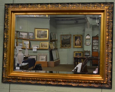 Lot 1307 - A reproduction gilt bevelled glass mirror, with rectangular plate and acanthus decorated frame,...