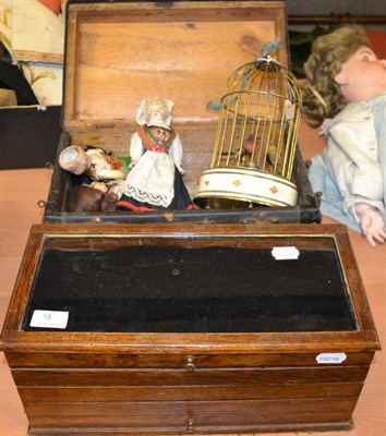 Lot 1356 - Dolls hinged trunk, circa 1950s clockwork group of two birds in a cage, assorted bisque,...