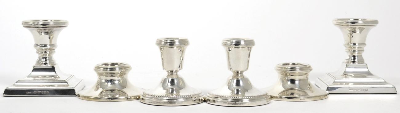 Lot 20 - A pair of dwarf silver candlesticks, on square bases; together with two further pairs of dwarf...