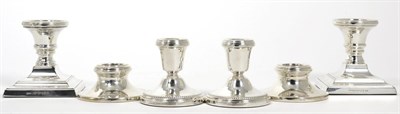 Lot 20 - A pair of dwarf silver candlesticks, on square bases; together with two further pairs of dwarf...