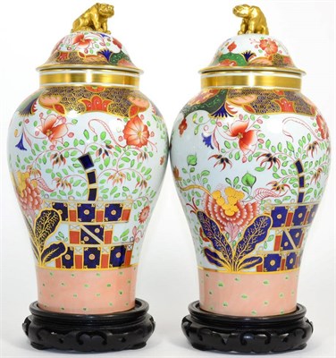 Lot 46 - A pair Spode of Imari pattern jars and covers, raised upon ebonised wooden bases