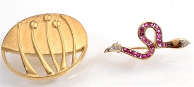 Lot 115 - A ruby and diamond snake brooch, channel set with calibré cut rubies and a diamond set tail...