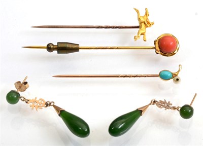 Lot 118 - An equestrian stickpin, modelled as a jockey on horseback; a coral stickpin, within a coiled...