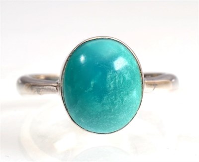 Lot 128 - An 18 carat white gold turquoise ring, an oval cabochon turquoise in a rubbed over setting, to...