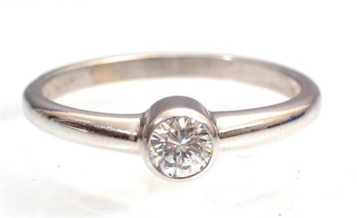 Lot 132 - An 18 carat white gold solitaire diamond ring, in a rubbed over setting, 0.25 carat...