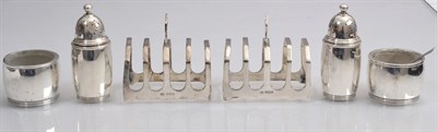 Lot 143 - A pair of silver toast racks, Viners Ltd, Sheffield 1933; and a four piece salt and pepper set,...