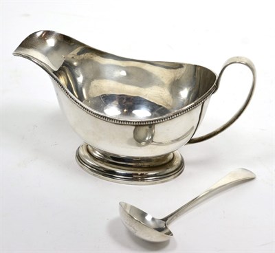 Lot 320 - A silver pedestal sauce boat, Birmingham 1933; and a matched sauce ladle (2)