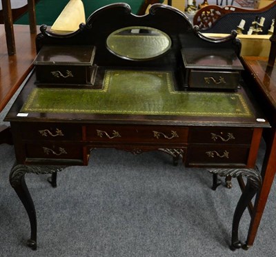 Lot 1098 - An Edwardian writing table, with mirror back, leather top, on foliate carved cabriole supports