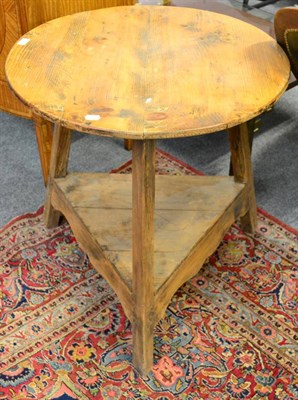 Lot 1105 - A 19th century pine cricket table with circular top and triangular shaped shelf