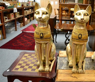 Lot 1150 - A pair of Egyptian style seated cat figures and a stamped wood games table