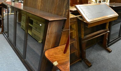 Lot 1160 - A large oak low bookcase with adjustable shelves and four glazed doors, together with an adjustable