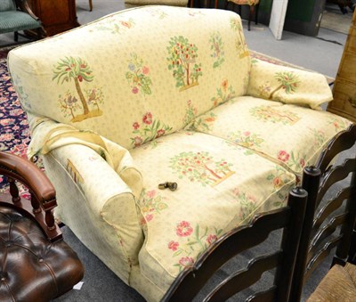 Lot 1343 - An early 20th century two seater settee upholstered in cream fabric printed with trees