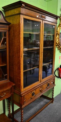 Lot 1412 - An early 20th century oak glazed bookcase on stand