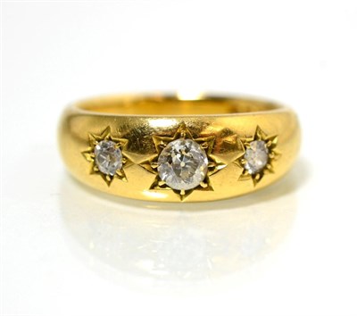 Lot 70 - An 18 carat gold diamond three stone ring, star set graduated old cut diamonds, to a tapering...