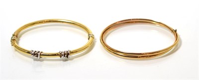 Lot 97 - A 9 carat gold twisted bar bangle, measures 6cm by 5.5cm and a two colour bangle, with white...