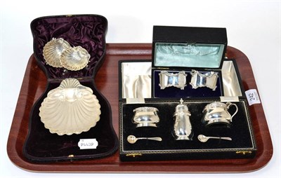 Lot 242 - A group silver including an oyster dish, a pair of napkin rings, a three piece condiment set...